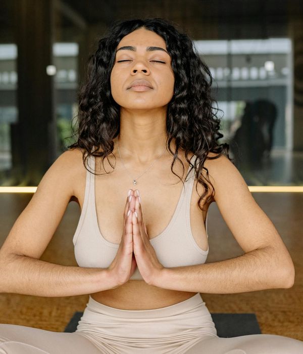 Woman in a mindful yoga pose in a studio with warm ember light.